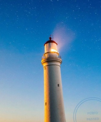 A lighthouse at dusk, framed as a perforated stamp